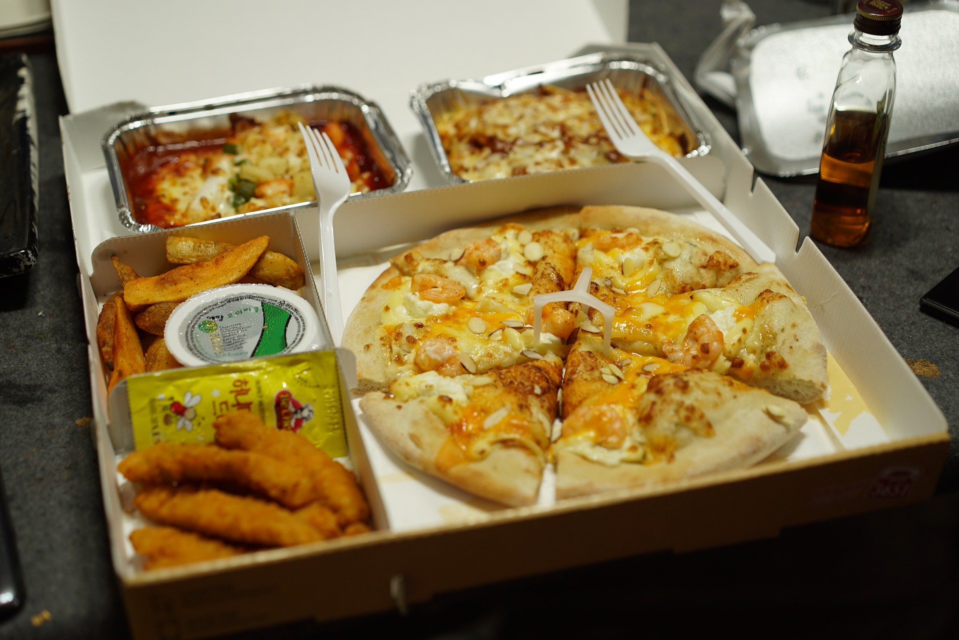 A delivery box with pizza and other foods